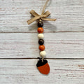 Acorn-shaped beaded hanging ornament with a burlap bow