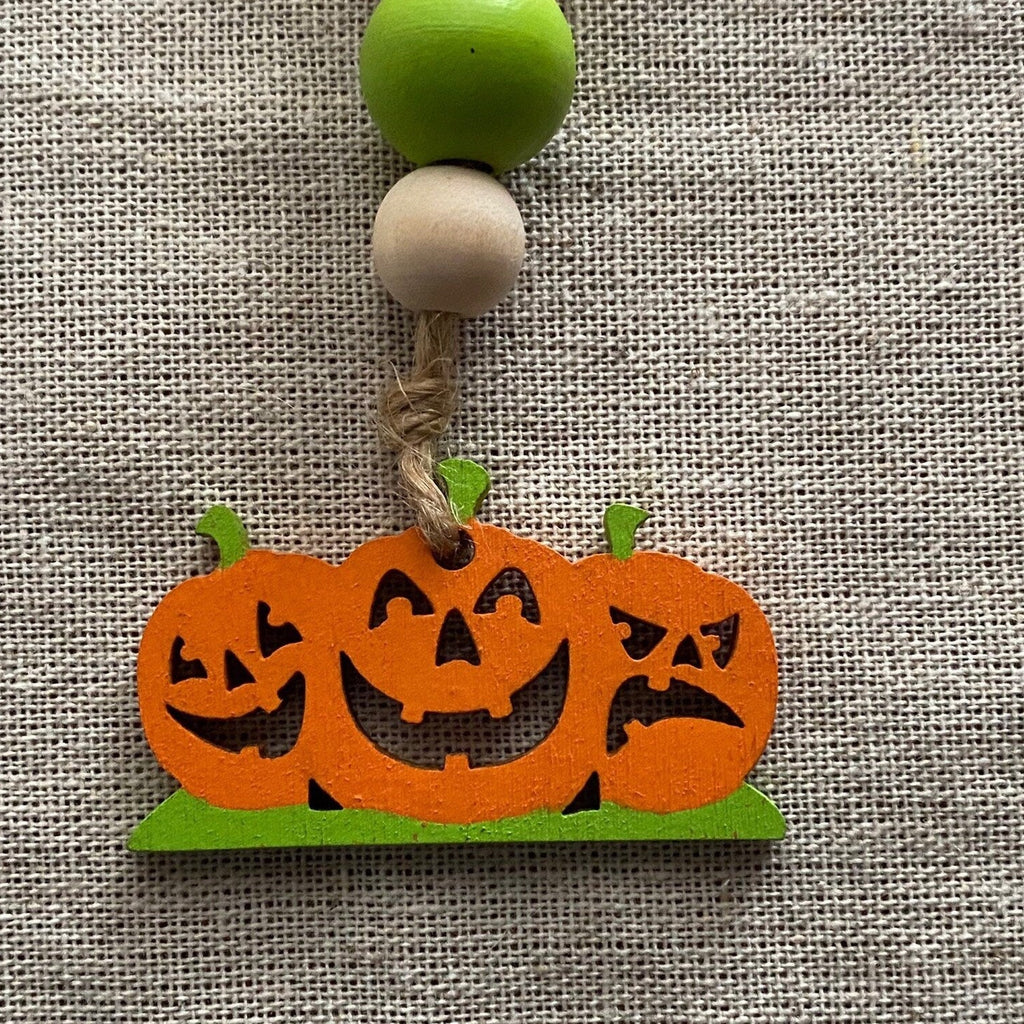 a wooden tag with 3 jackolanterns